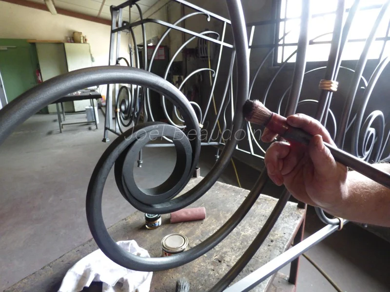 Pièce de ferronnerie en cours de façonnage sur un établi