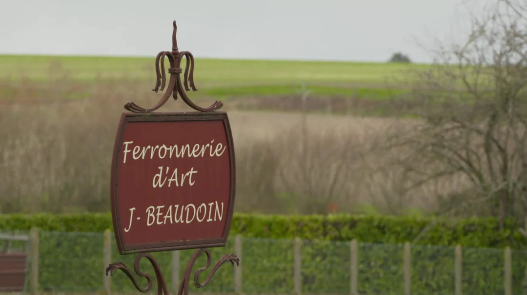 Panneau de l’atelier de ferronnerie Joël Beaudoin au bord d’un champ